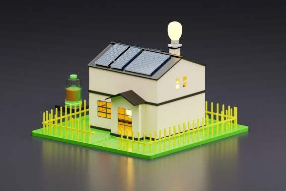 A model house with solar panels, a light bulb, and a small fence on a green base.